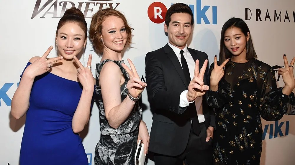 Four cast members flashing peace signs at a Viki and Variety press event